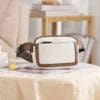 A white and brown fanny pack sitting on top of a table